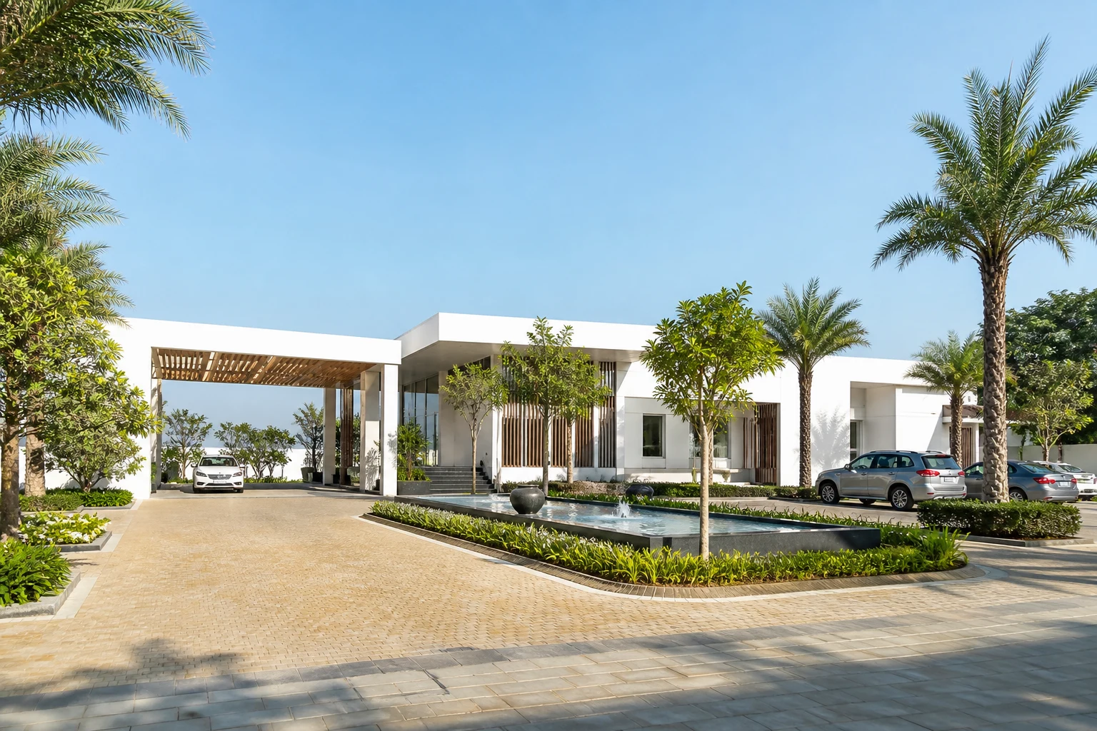 A bright daylight clubhouse arrival court with landscaped water feature and modern architecture
